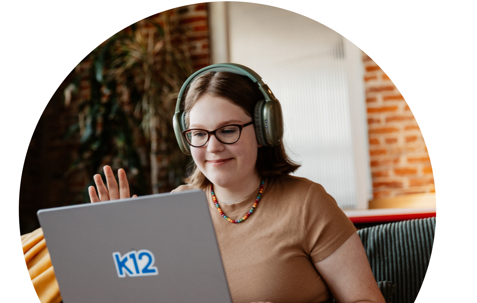 Student with her laptop wearing a green pair of headphones