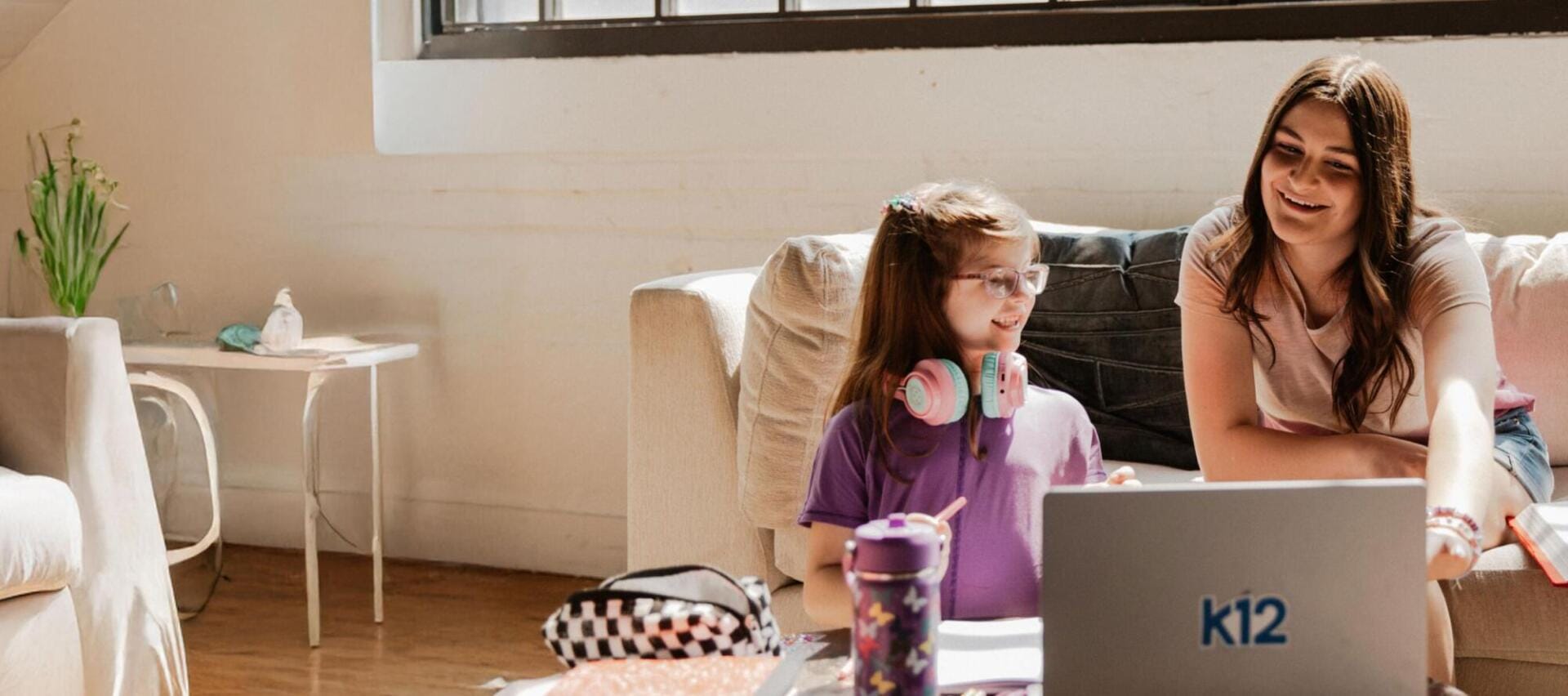 Mother and daughter working together with their laptop at home