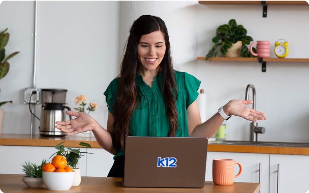 Teacher working with their laptop at home wearing a green shirt